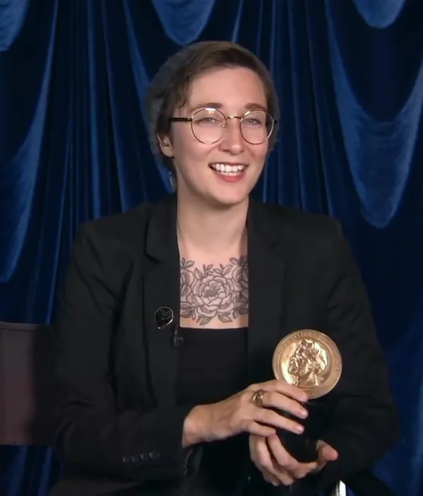 Dana Terrace holding a Peabody Award medal during her acceptance speech