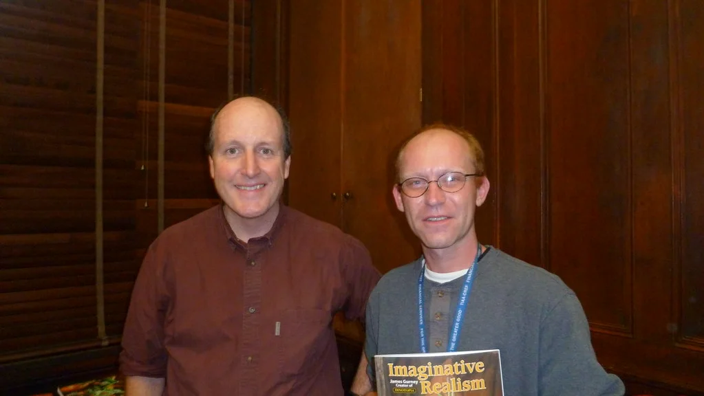 James Gurney standing with a fan holding a copy of his book Imaginative Realism after a lecture