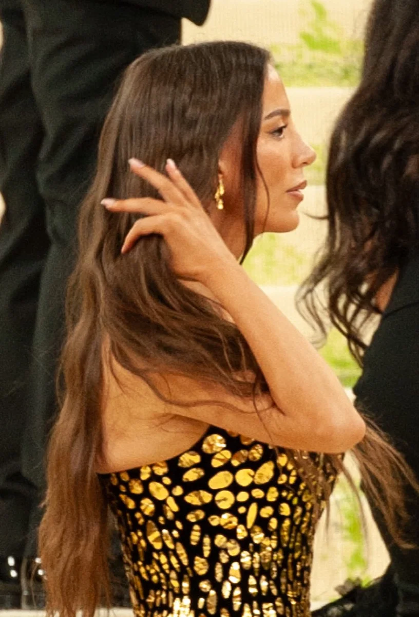 Mira Murati in profile at the 2026 Met Gala, wearing a gold-patterned gown.