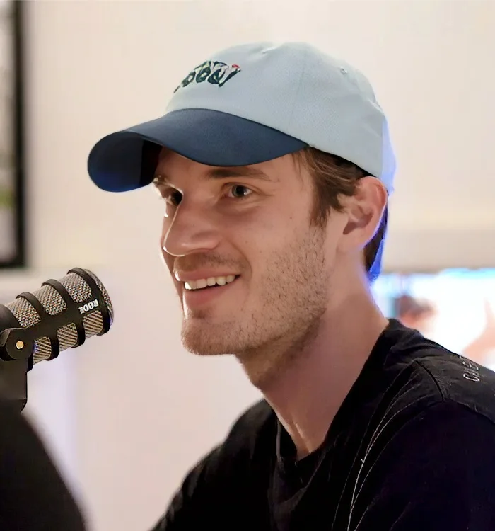 Felix Kjellberg in a cap speaking into a podcast microphone