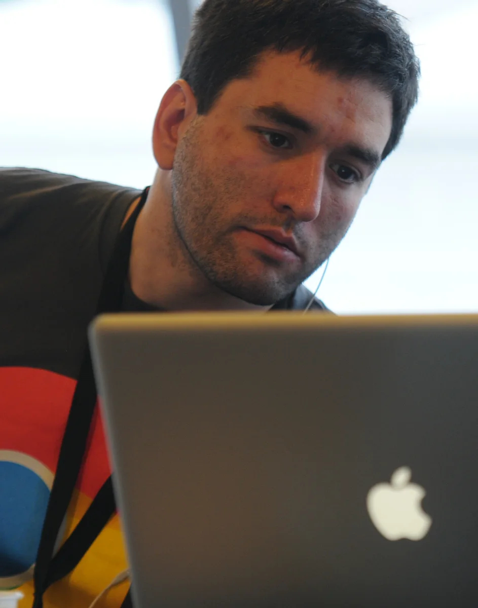 Ricardo Cabello working on a laptop at a hackathon