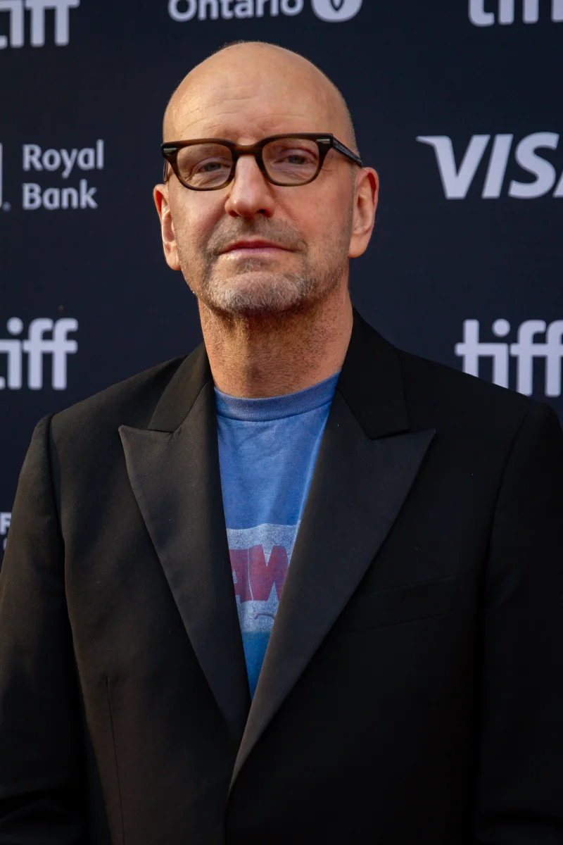 Steven Soderbergh in glasses and a black blazer over a Jaws T-shirt on the TIFF red carpet